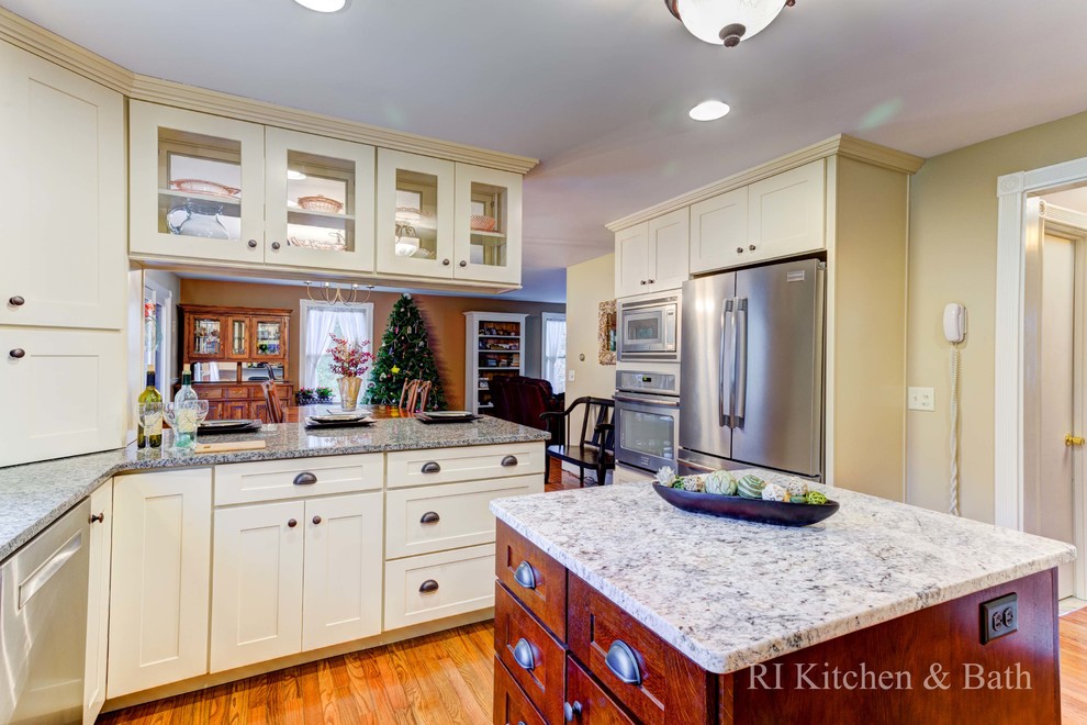 Large transitional u-shaped light wood floor eat-in kitchen photo in Providence with an undermount sink, shaker cabinets, beige cabinets, granite countertops, brown backsplash, porcelain backsplash, stainless steel appliances and an island