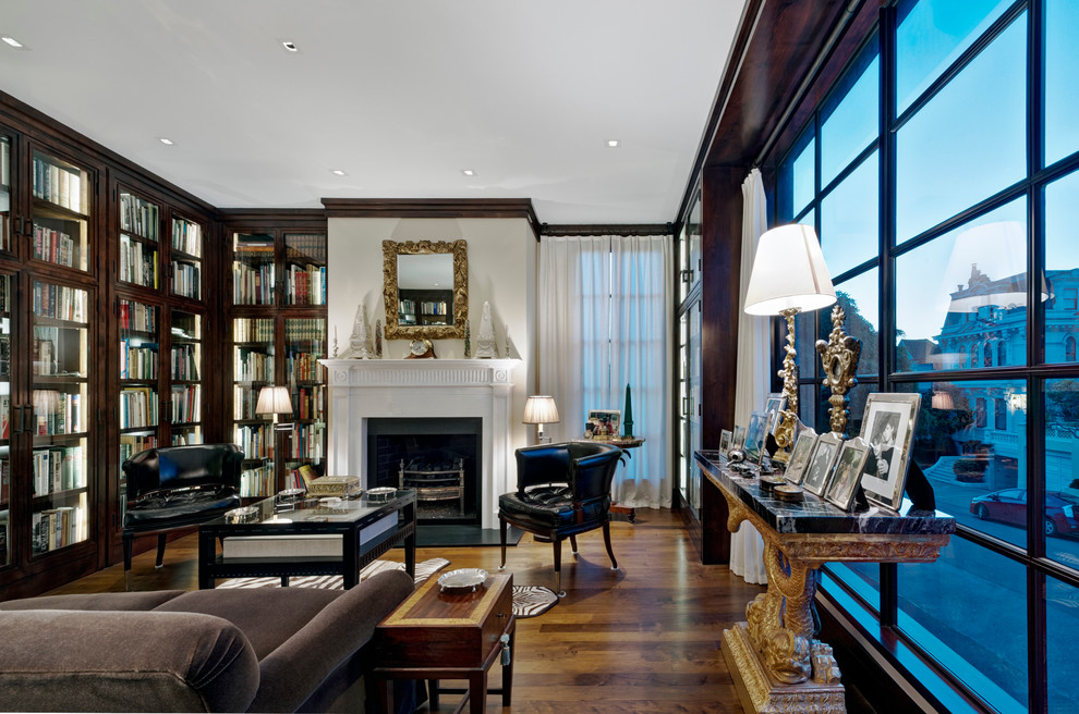 Traditional living room in San Francisco with a library, white walls, dark hardwood floors and a standard fireplace.