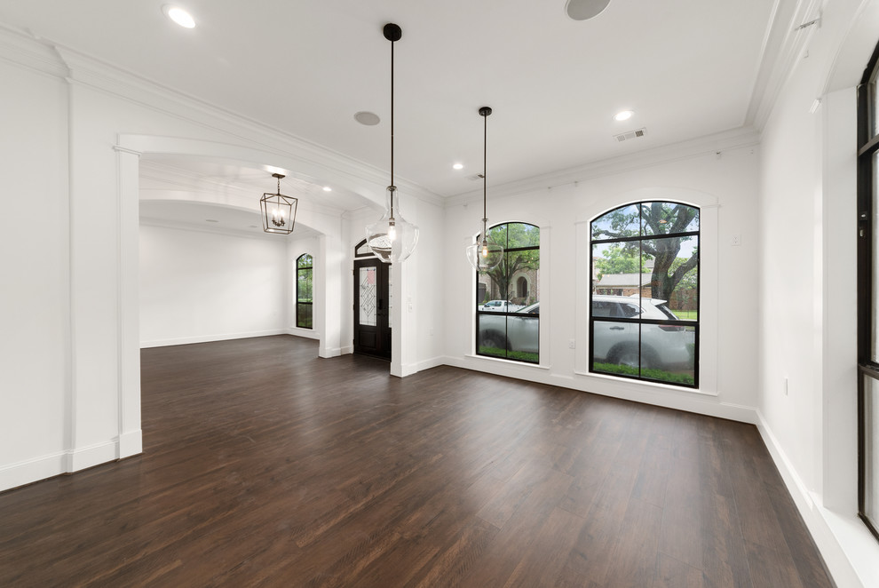 Large transitional separate dining room in Houston with white walls, laminate floors, no fireplace and brown floor.