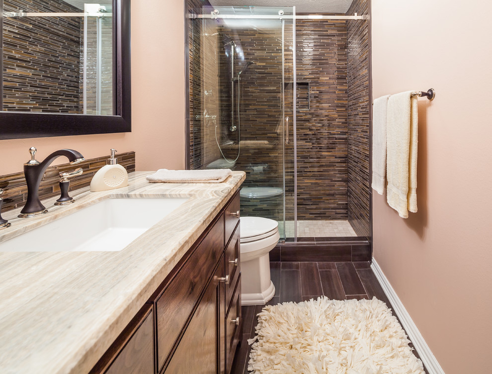 Design ideas for a mid-sized transitional 3/4 bathroom in Houston with an undermount sink, recessed-panel cabinets, dark wood cabinets, granite benchtops, a two-piece toilet, brown tile, glass tile, orange walls and ceramic floors.