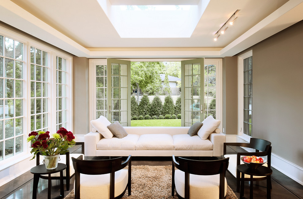 This is an example of a modern sunroom in Minneapolis with concrete floors and a skylight.
