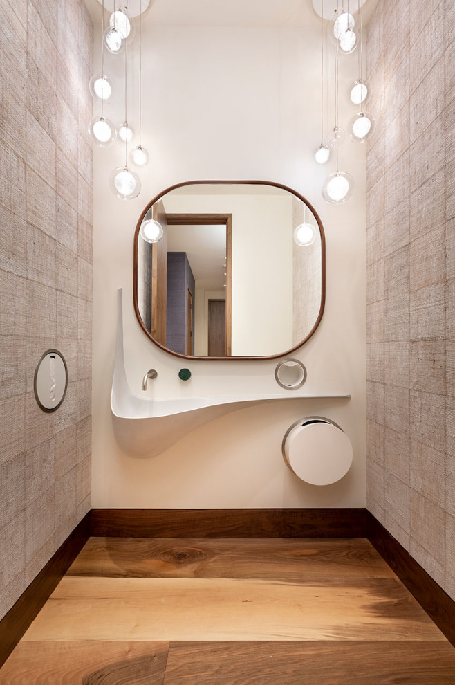 Réalisation d'un WC et toilettes design de taille moyenne avec des portes de placard beiges, un sol en bois brun, un plan de toilette en béton, un sol marron, un plan de toilette gris, meuble-lavabo suspendu et du papier peint.