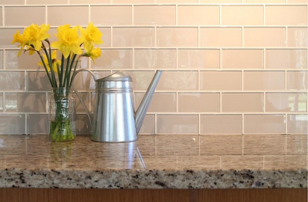 Transitional medium tone wood floor kitchen photo with raised-panel cabinets, white cabinets, granite countertops, beige backsplash, glass tile backsplash and stainless steel appliances