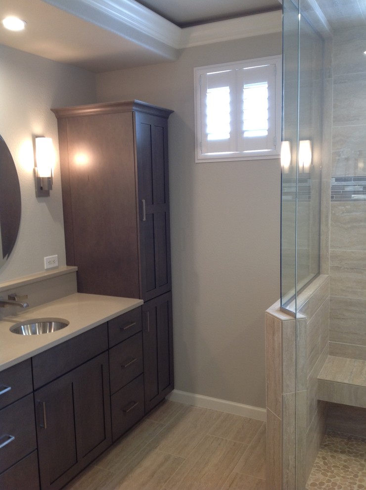 Inspiration for a mid-sized transitional 3/4 porcelain tile and double-sink corner shower remodel in Denver with shaker cabinets, dark wood cabinets, beige walls, an undermount sink and solid surface countertops