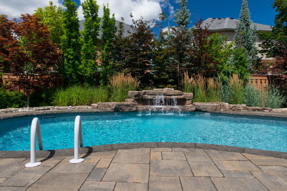 Example of a transitional backyard stone and freeform pool design in Toronto