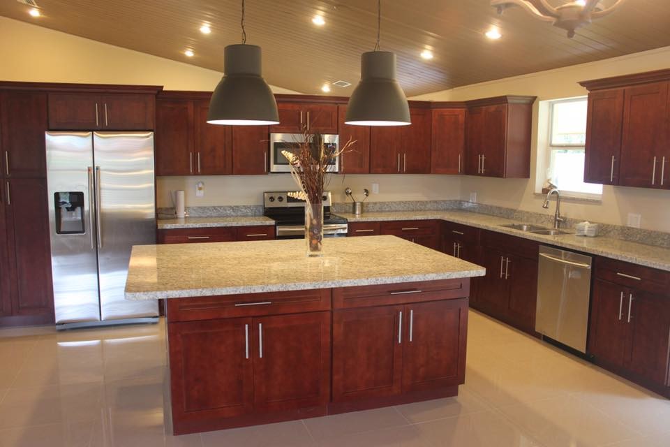 Eat-in kitchen - large transitional l-shaped porcelain tile and beige floor eat-in kitchen idea in Miami with a double-bowl sink, shaker cabinets, red cabinets, granite countertops, stainless steel appliances, an island and brown countertops