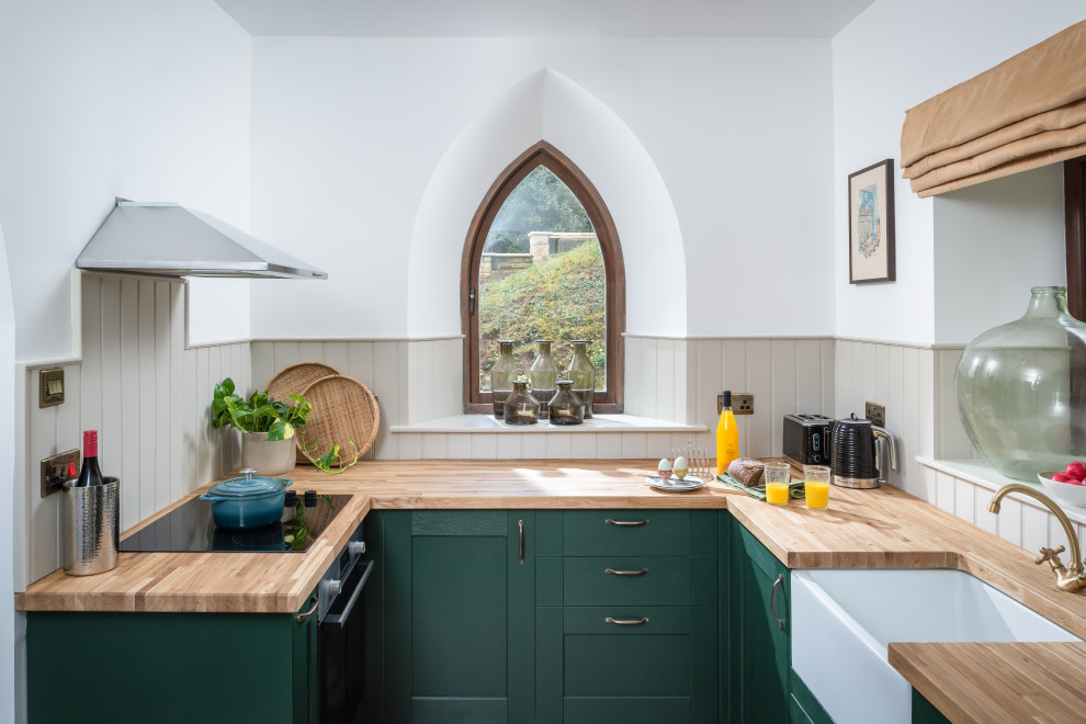 Idéer för att renovera ett litet eklektiskt u-kök, med en rustik diskho, luckor med infälld panel, gröna skåp, träbänkskiva och rostfria vitvaror