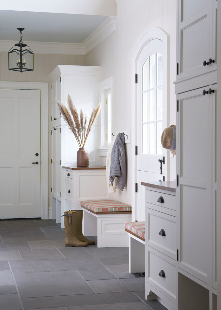 Inspiration for a traditional mudroom in New York with beige walls, a dutch front door, a white front door and grey floor.