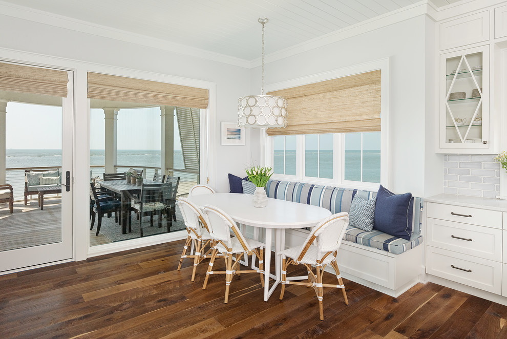 This is an example of a beach style dining room in Charleston with grey walls, dark hardwood floors and brown floor.