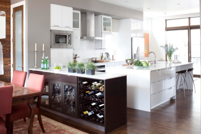 Inspiration for a contemporary galley eat-in kitchen in Denver with flat-panel cabinets, white cabinets, white splashback, stainless steel appliances, dark hardwood floors and with island.