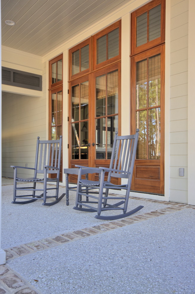 Photo of a mid-sized traditional front yard verandah in Charleston with brick pavers and a roof extension.