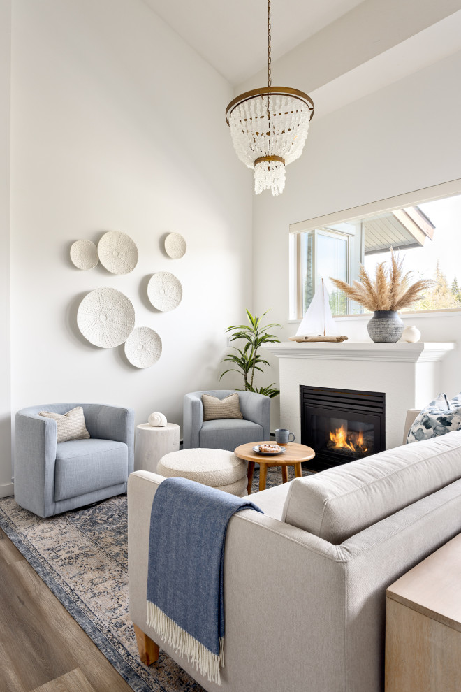 Medium sized coastal open plan living room in Vancouver with white walls, a standard fireplace, a plastered fireplace surround and beige floors.