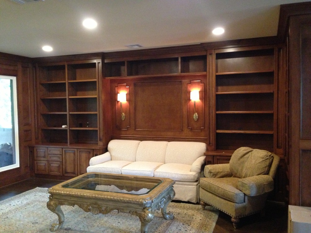 This is an example of a mid-sized traditional home office in Houston with a library and dark hardwood floors.