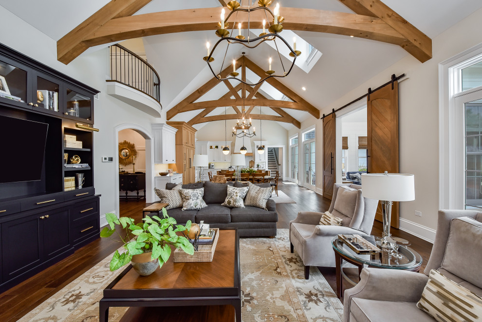 Huge elegant open concept medium tone wood floor, brown floor and vaulted ceiling family room photo in Chicago with white walls, a standard fireplace and a stone fireplace