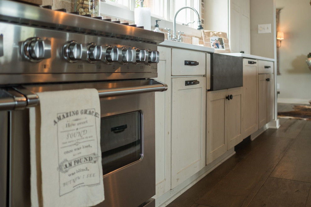 Open concept kitchen - large transitional galley dark wood floor and brown floor open concept kitchen idea with a farmhouse sink, shaker cabinets, quartz countertops, brown backsplash, brick backsplash, stainless steel appliances and an island