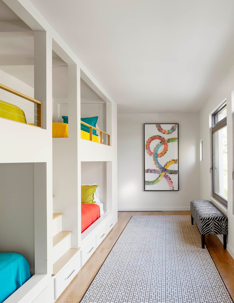 Photo of a contemporary gender-neutral kids' room in Dallas with white walls and light hardwood floors.