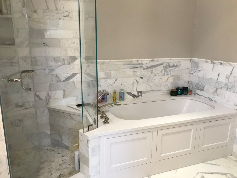 Example of a mid-sized transitional master white tile and marble tile ceramic tile and white floor alcove shower design with recessed-panel cabinets, white cabinets, an undermount tub, a two-piece toilet, gray walls, an undermount sink, quartz countertops and white countertops