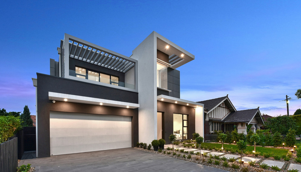 Photo of a mid-sized contemporary two-storey concrete grey house exterior in Sydney with a flat roof and a metal roof.