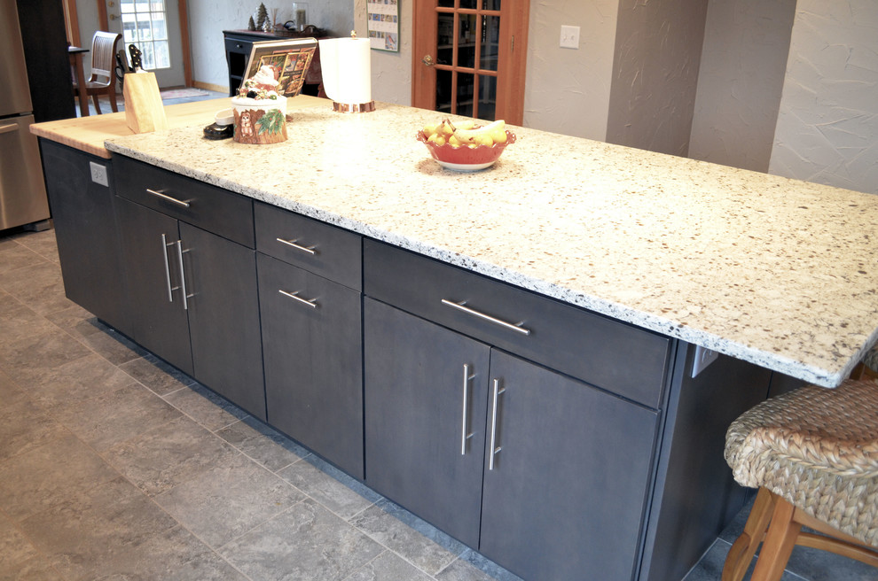 Transitional ceramic tile kitchen photo with an undermount sink, flat-panel cabinets, gray cabinets, quartz countertops, gray backsplash, ceramic backsplash, stainless steel appliances and an island