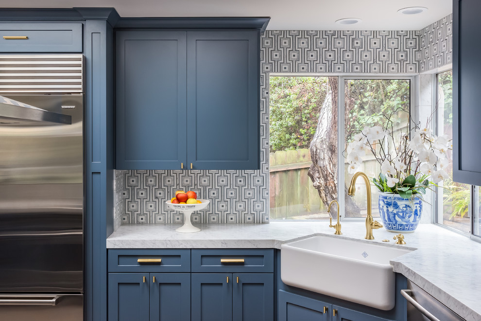 Photo of a mid-sized transitional galley kitchen in San Diego with a farmhouse sink, recessed-panel cabinets, blue cabinets, granite benchtops, grey splashback, ceramic splashback, stainless steel appliances and dark hardwood floors.
