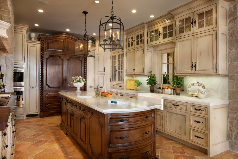 Design ideas for a large mediterranean u-shaped eat-in kitchen in San Diego with a farmhouse sink, recessed-panel cabinets, distressed cabinets, marble benchtops, white splashback, stone slab splashback, panelled appliances, terra-cotta floors, with island and red floor.