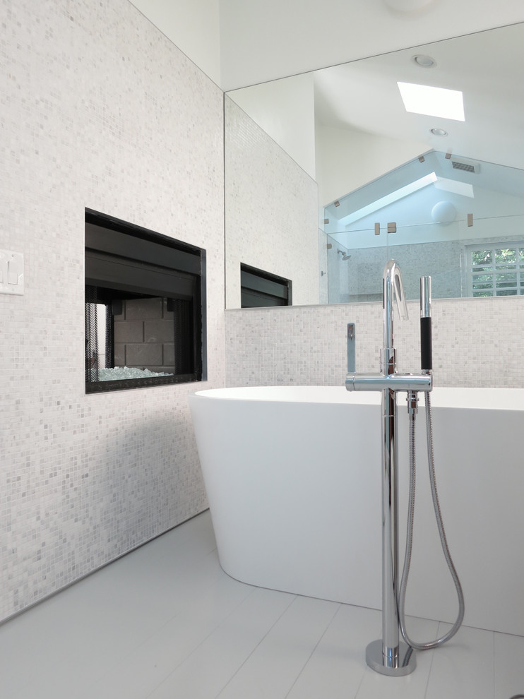 Large modern master bathroom in Los Angeles with a freestanding tub, white walls and white floor.