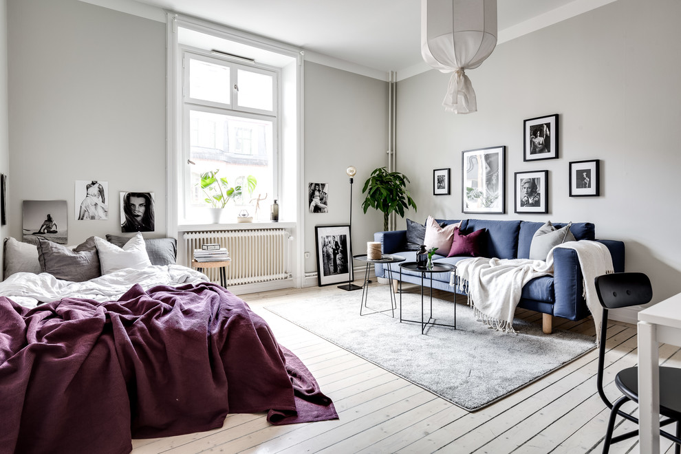 Inspiration for a mid-sized scandinavian open concept living room in Stockholm with grey walls, light hardwood floors and white floor.