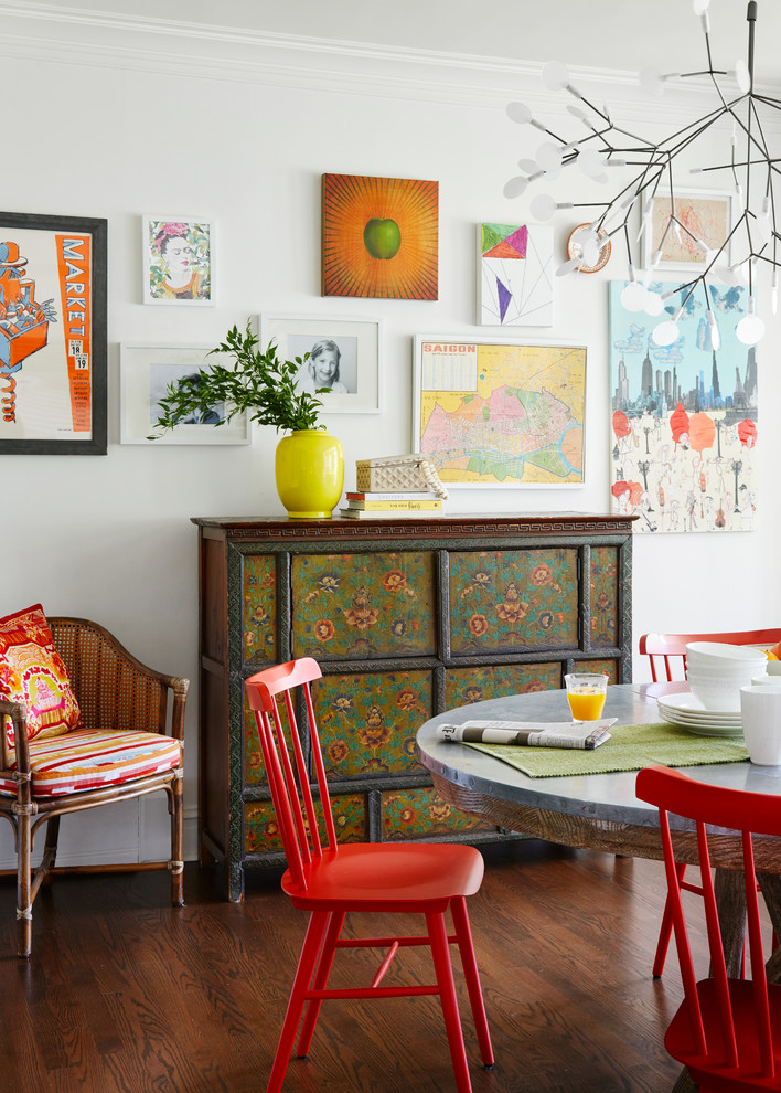 This is an example of an eclectic dining room in Chicago with white walls and dark hardwood floors.