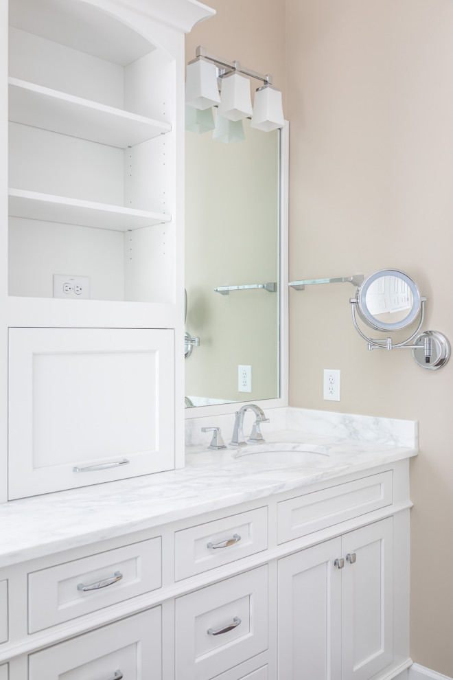 Mid-sized transitional master white tile and marble tile dark wood floor and brown floor freestanding bathtub photo in Raleigh with recessed-panel cabinets, white cabinets, beige walls, an undermount sink, marble countertops, a hinged shower door and white countertops