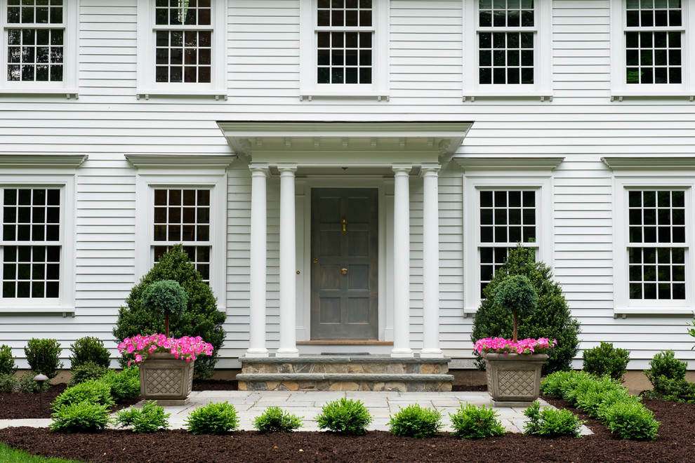 Inspiration for a traditional three-storey white exterior in New York with vinyl siding and a gable roof.