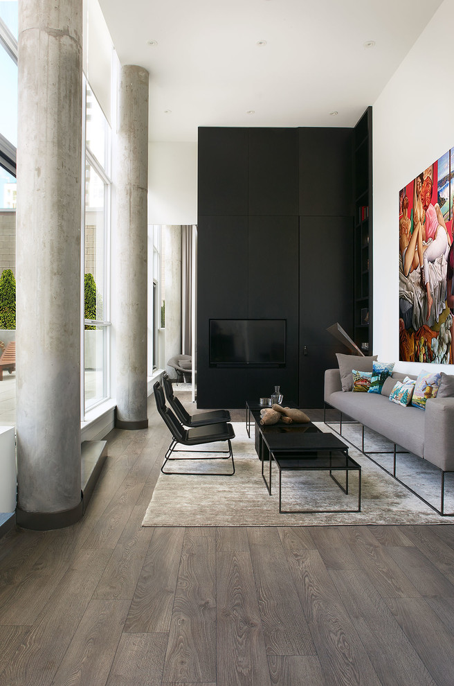 Modern open concept living room in Toronto with white walls, dark hardwood floors, a wall-mounted tv and brown floor.