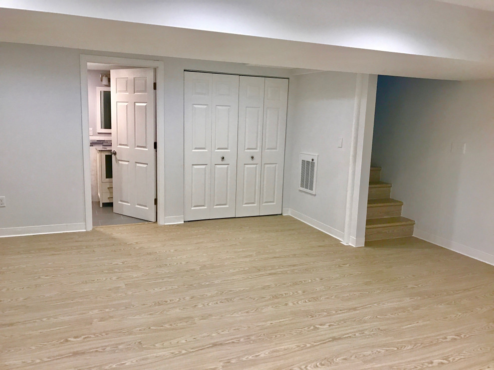 Inspiration for a large modern basement in Boston with laminate floors and beige floor.