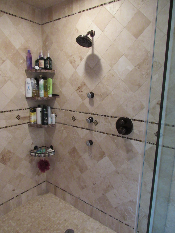 This is an example of a mid-sized traditional master bathroom in New York with raised-panel cabinets, dark wood cabinets, a drop-in tub, an open shower, a one-piece toilet, beige tile, brown tile, porcelain tile, multi-coloured walls, travertine floors, an undermount sink and granite benchtops.