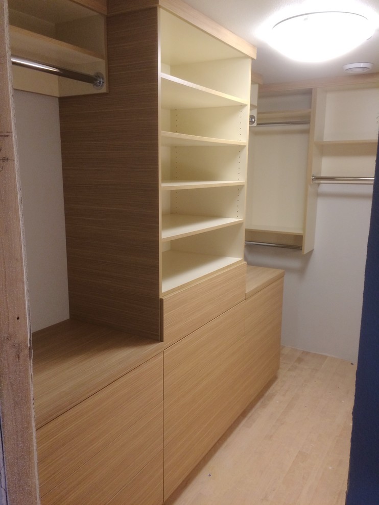 Small contemporary gender-neutral walk-in wardrobe in Seattle with flat-panel cabinets and beige cabinets.