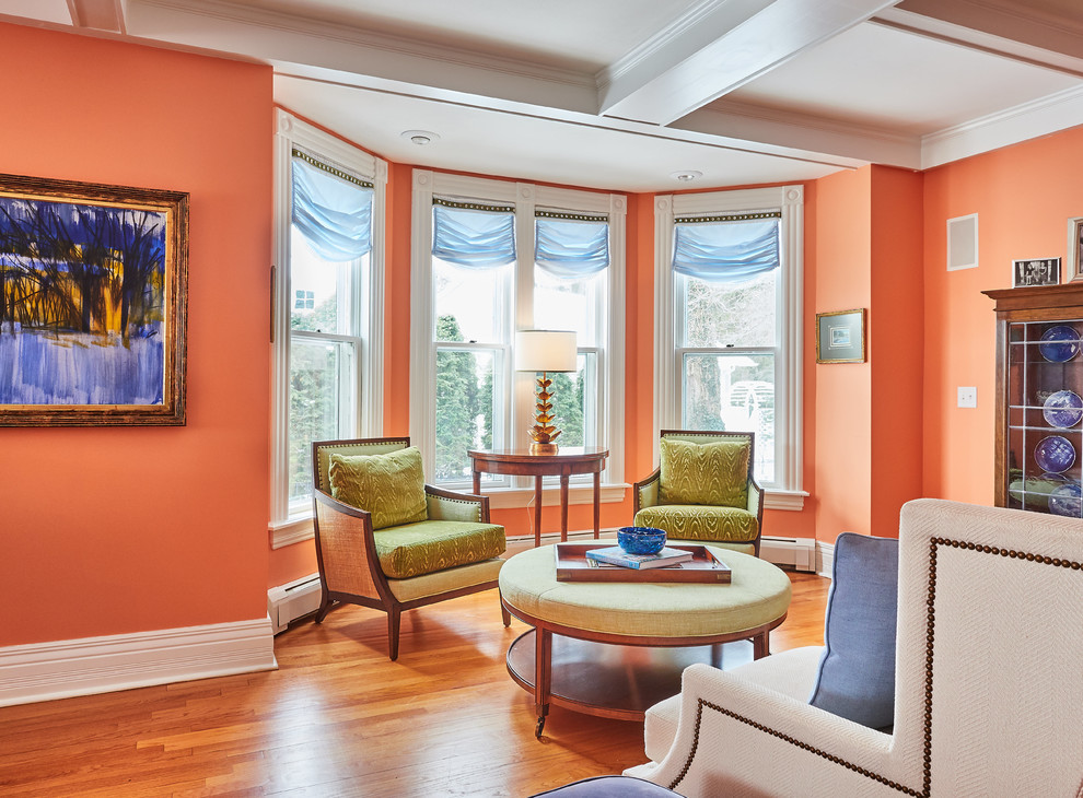 Mid-sized transitional formal open concept living room in New York with orange walls, medium hardwood floors, no tv, brown floor, a standard fireplace and a tile fireplace surround.