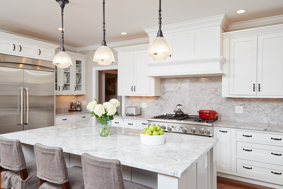 Beach style kitchen in Boston with a farmhouse sink, beaded inset cabinets, white cabinets, marble benchtops, white splashback, subway tile splashback, stainless steel appliances, medium hardwood floors and with island.