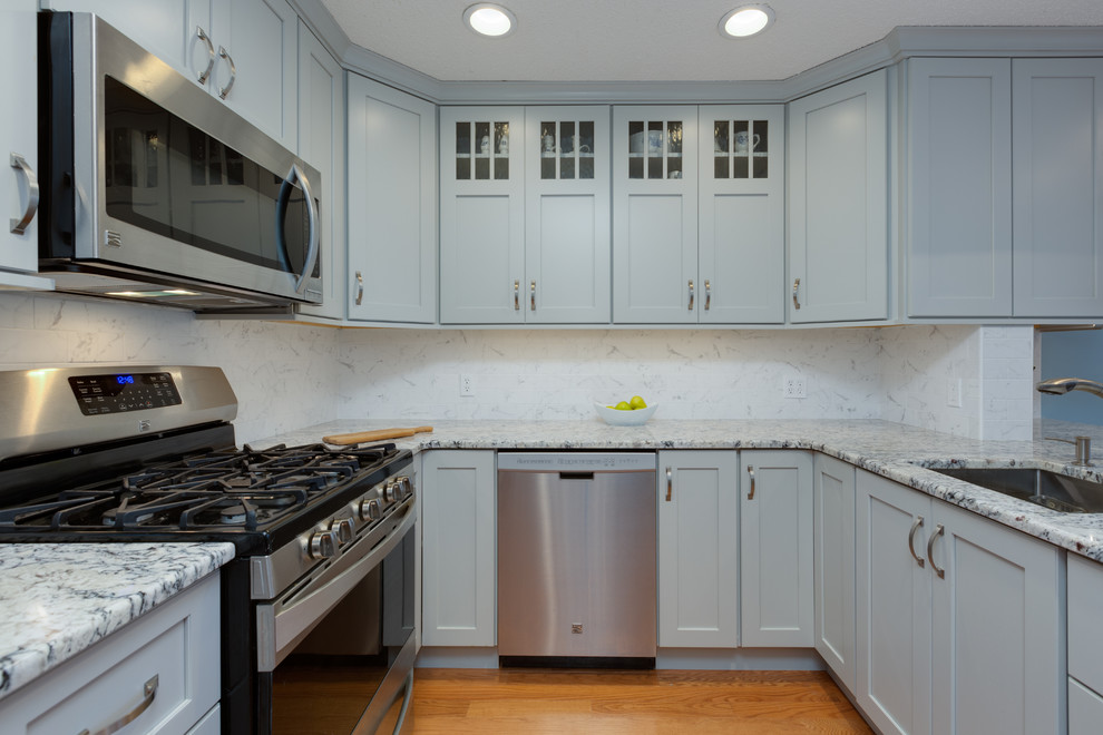 Design ideas for a mid-sized transitional u-shaped eat-in kitchen in Boston with an undermount sink, shaker cabinets, grey cabinets, granite benchtops, stone tile splashback, stainless steel appliances, medium hardwood floors and a peninsula.