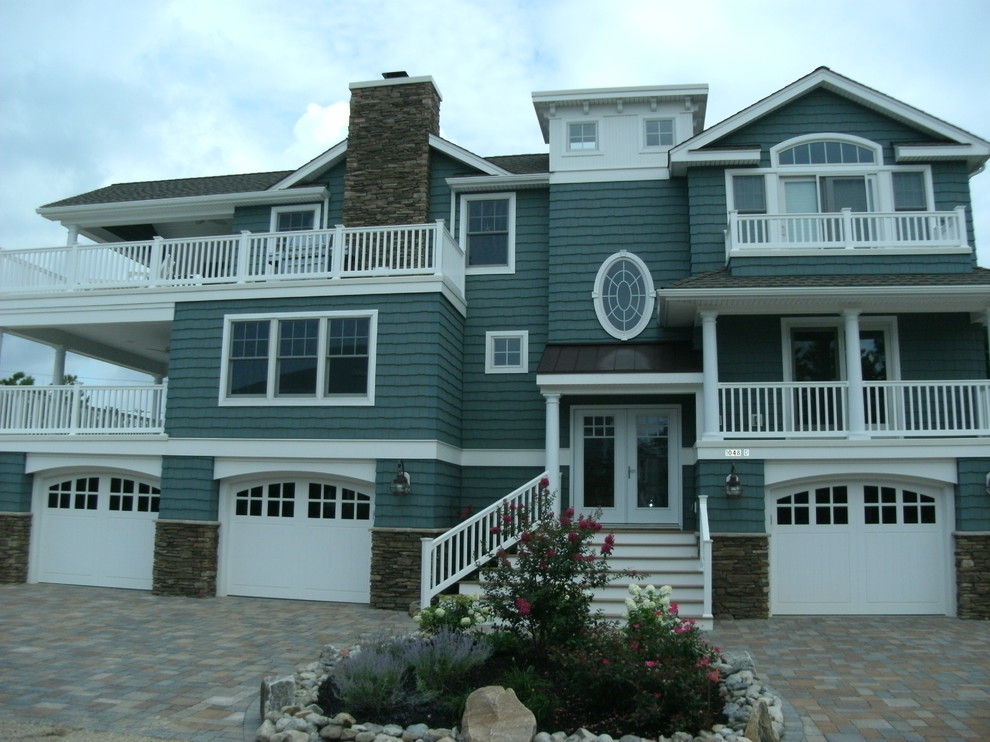 This is an example of a mid-sized traditional three-storey green house exterior in New York with vinyl siding, a gable roof and a shingle roof.