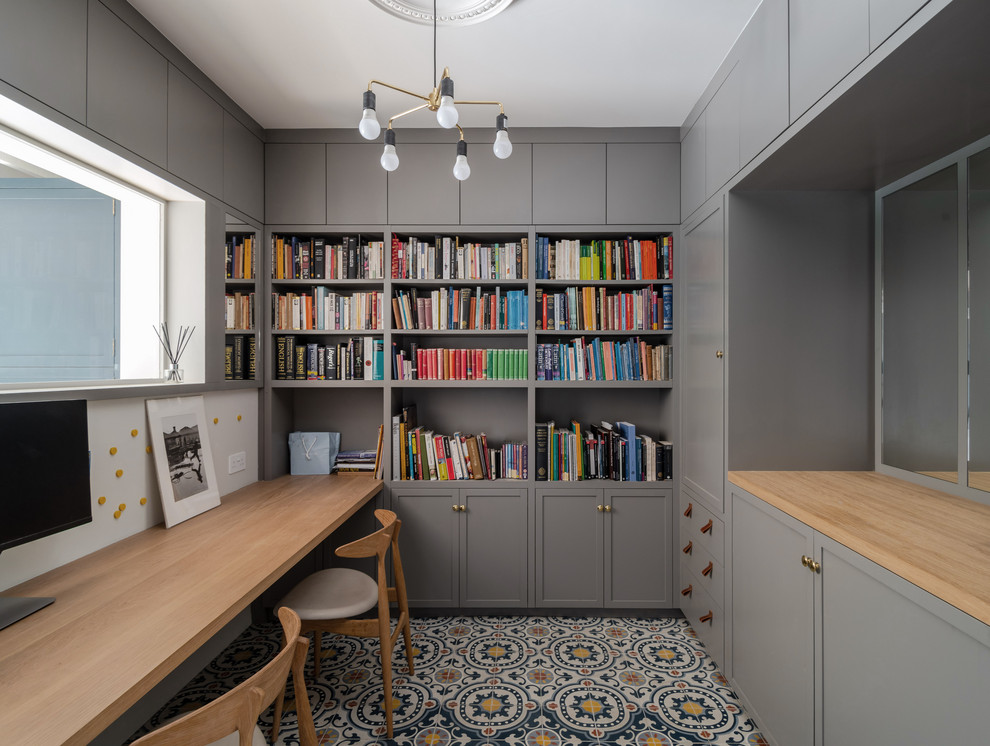 Inspiration for a transitional home office in London with a built-in desk and multi-coloured floor.