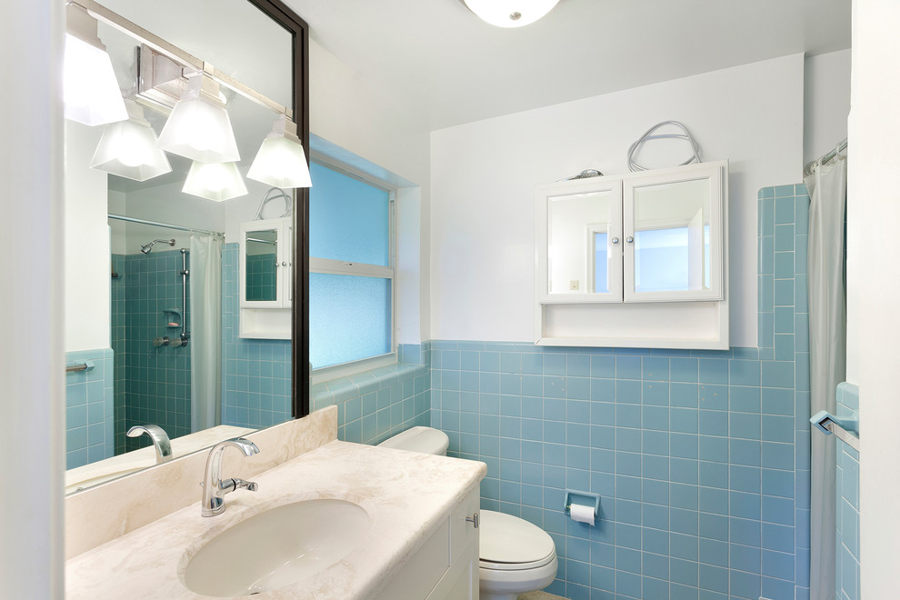 Expansive traditional kids bathroom in Other with recessed-panel cabinets, white cabinets, an alcove shower, a one-piece toilet, blue tile, ceramic tile, grey walls, ceramic floors, an undermount sink, marble benchtops, beige floor, a shower curtain and beige benchtops.