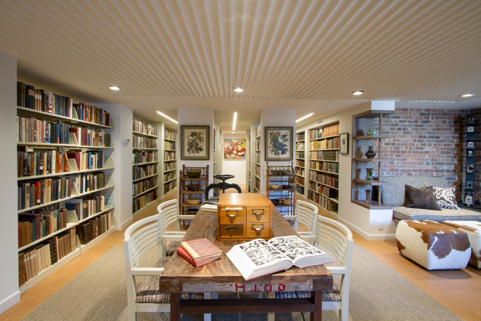 Cette photo montre un grand salon rétro ouvert avec une bibliothèque ou un coin lecture, un mur blanc, un sol en liège, une cheminée standard, un manteau de cheminée en brique, un sol marron, un plafond décaissé et un mur en parement de brique.
