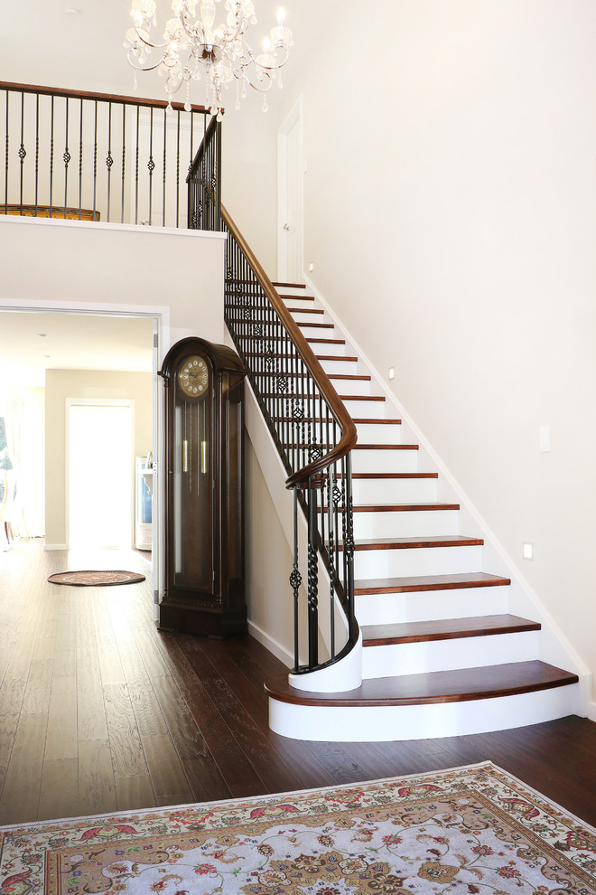 Inspiration for a mid-sized traditional wood straight staircase in Wellington with painted wood risers and metal railing.