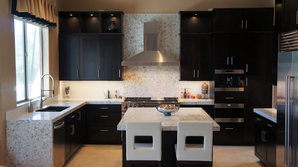 Mid-sized transitional l-shaped porcelain tile and beige floor kitchen photo in Phoenix with an undermount sink, recessed-panel cabinets, dark wood cabinets, quartz countertops, white backsplash, ceramic backsplash, stainless steel appliances and an island
