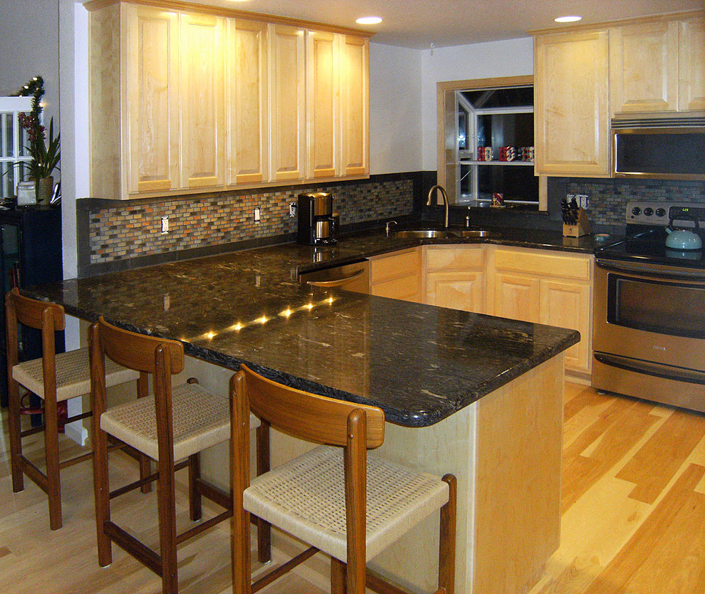 Kitchen - brown floor kitchen idea with raised-panel cabinets and stainless steel appliances