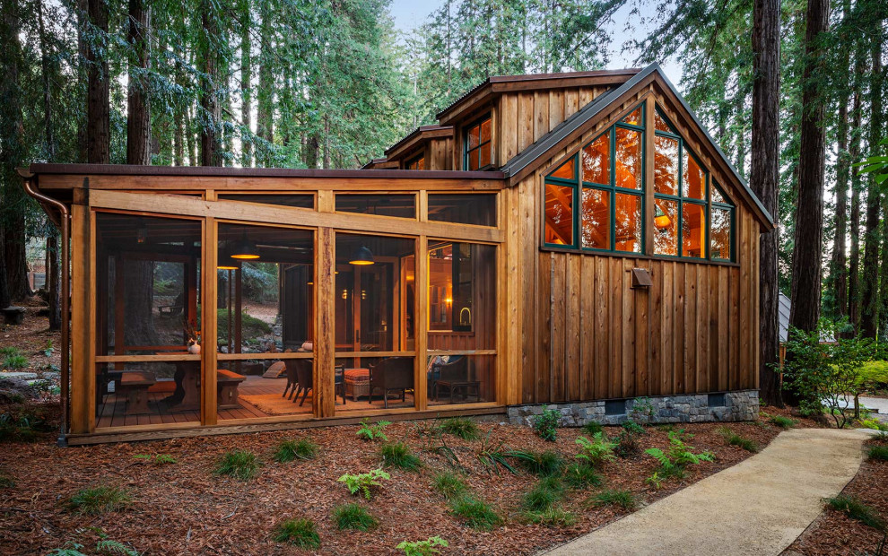 Mid-sized country one-storey brown house exterior in San Francisco with wood siding, a gable roof and a metal roof.