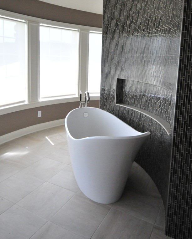 Example of a large transitional master limestone floor and white floor freestanding bathtub design with beige walls