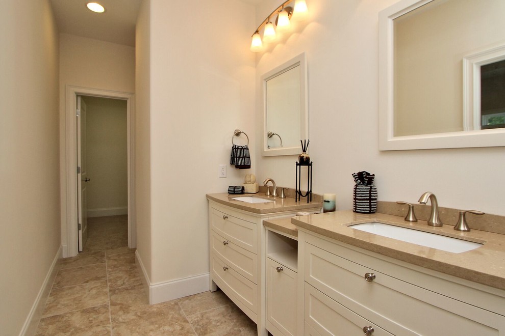 This is an example of a mid-sized transitional master bathroom in Orange County with furniture-like cabinets, white cabinets, a corner tub, a shower/bathtub combo, white walls, ceramic floors, an undermount sink and solid surface benchtops.