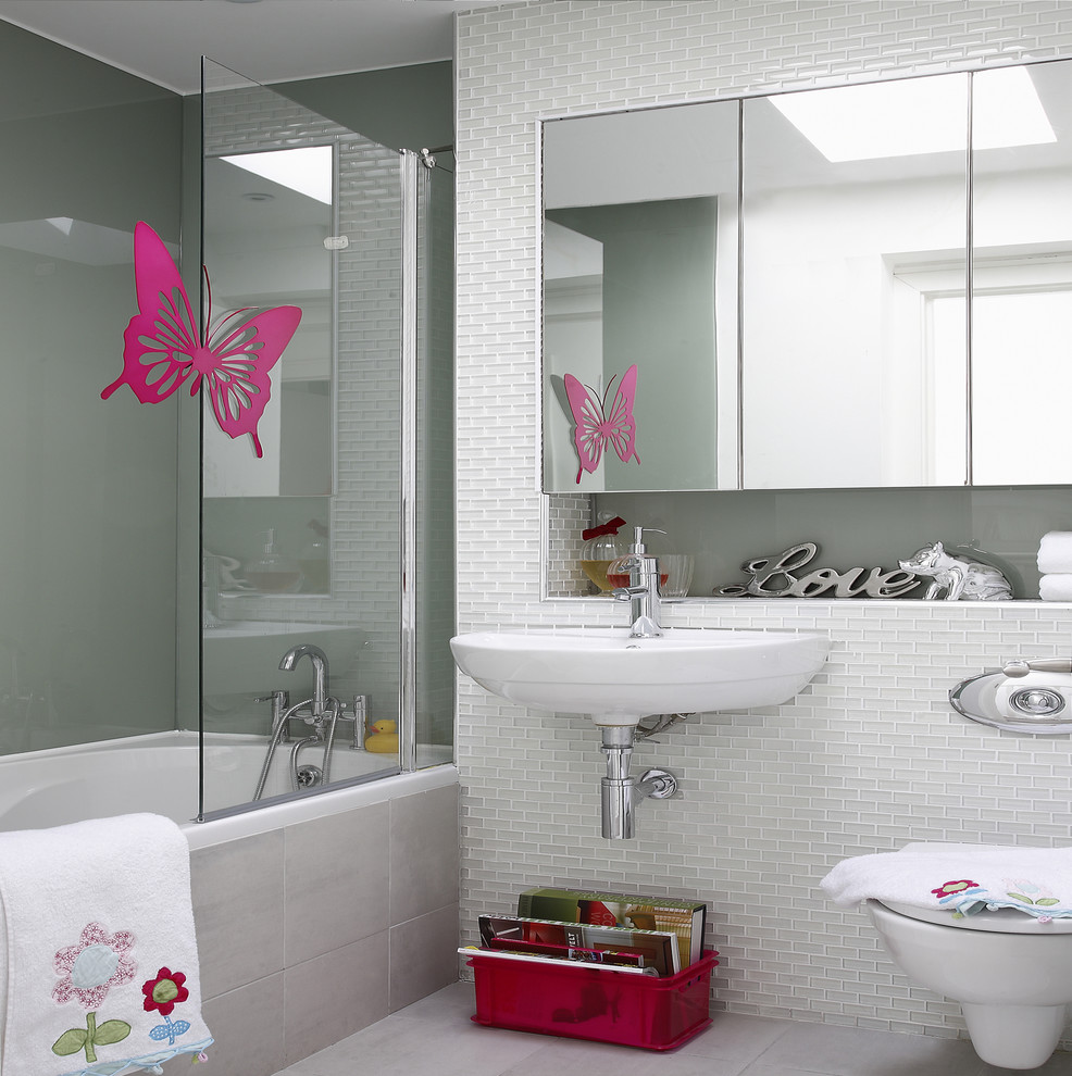 This is an example of a contemporary bathroom in Dublin with a shower/bathtub combo, a wall-mount sink and a wall-mount toilet.