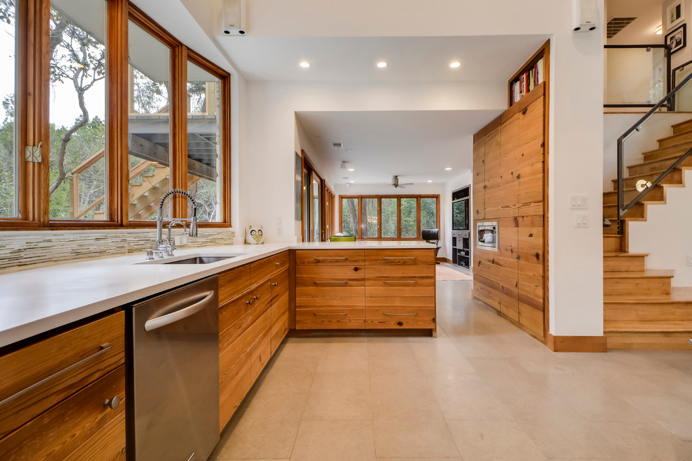 This is an example of a mid-sized contemporary l-shaped open plan kitchen in Austin with an undermount sink, flat-panel cabinets, medium wood cabinets, quartzite benchtops, stainless steel appliances, with island and travertine floors.