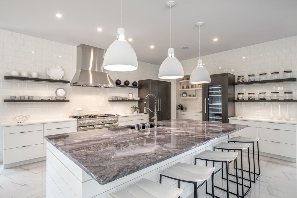 This is an example of a large contemporary l-shaped open plan kitchen in Other with an undermount sink, flat-panel cabinets, white cabinets, white splashback, ceramic splashback, stainless steel appliances, ceramic floors, with island, white floor, white benchtop and quartzite benchtops.